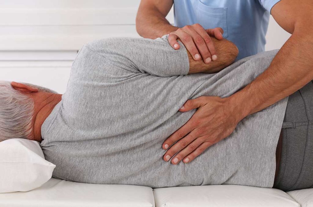 A person receiving a professional back massage in a calm therapy room setting